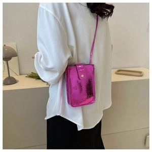 Rear view of model wearing a glossy rose red croc-embossed phone bag with gold metal buckle