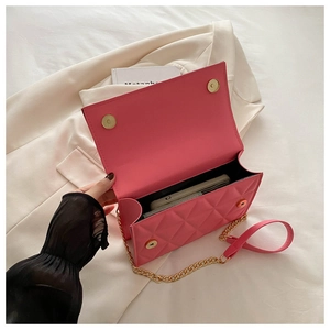 Detailed internal view of pink quilted handbag showing space for phone and gold chain