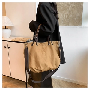 Vista laterale della borsa tote in tela kaki con tracolla marrone regolabile
