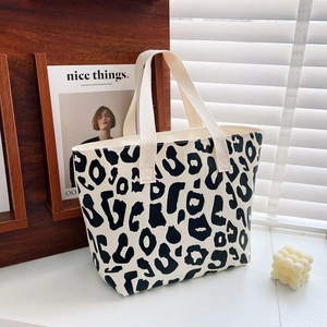 Detailed macro view of black and white leopard print on a premium canvas tote handbag
