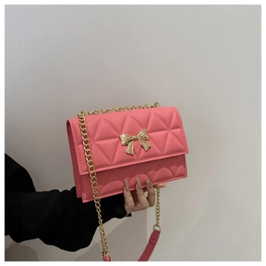 Detail showing pink quilted leather texture and golden bow buckle on a flap handbag
