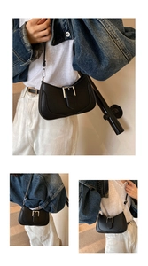 Detail of black crescent shoulder bag with silver buckle and litchi texture leather