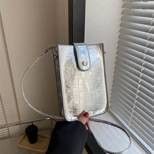 Detail shot of silver metallic crocodile texture on vertical mobile phone crossbody bag