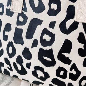 Close-up detail of black and white leopard print canvas fabric texture on a tote bag