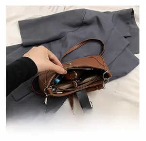 Detail view of brown pebbled leather crescent bag interior with zipper and silver hardware