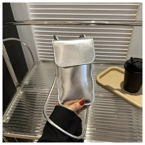 Gros plan détaillé d'un sac pour téléphone argenté avec fine bandoulière tressée