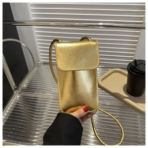Detailweergave van de goudkleurige mini-schoudertas met fijne stiksels en slanke riem
