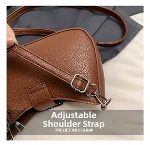 Detail of adjustable strap with silver hardware on brown litchi pattern bag