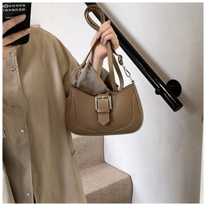 Close-up of brown litchi pattern leather hobo bag with silver buckle and adjustable strap