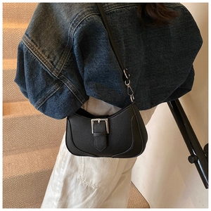Close-up of a black lychee texture crescent bag with a silver metal buckle detail