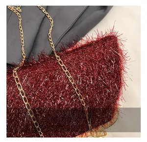 Détail de la texture des franges rouges et de la bandoulière dorée du sac de soirée