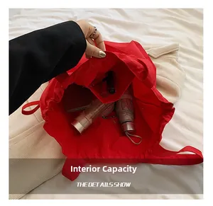 Internal capacity of the red nylon tote bag showing pockets for umbrella and phone