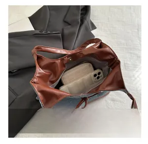 Vue détaillée de l'intérieur spacieux du sac cabas en denim et cuir avec fermoir aimanté