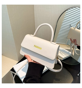 Detailed macro view of white pebble-grain faux leather small square bag with yellow lettering