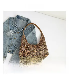 Dettaglio della trama leopardata e del manico in pelle marrone della borsa hobo