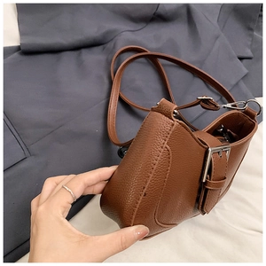 Detail of vintage brown lychee grain texture handbag with silver hardware and strap
