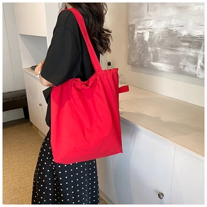 Detail of red nylon bucket bag showing soft texture and spacious interior with drawstrings