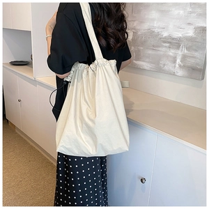 Detail of off-white nylon shoulder bag with a unique drawstring pleated top closure