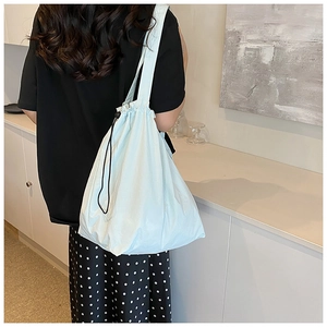Detail view of light blue nylon bucket bag showing drawstring closure and texture