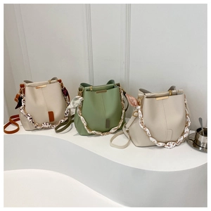 Chic bucket bags in beige and green featuring silk scarf handles and gold hardware