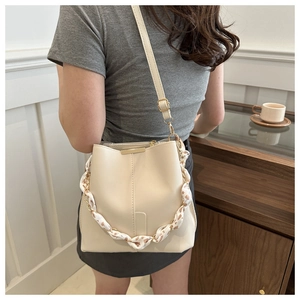 Detail of off-white bucket bag with silk scarf wrapped chain handle and PU leather texture