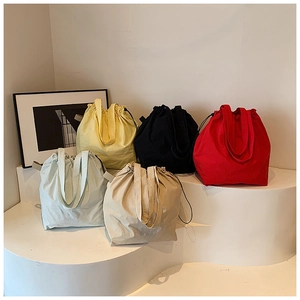 Detail view of colorful nylon bucket bags with drawstring closure on display