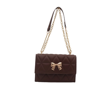 Brown quilted crossbody bag with gold bow buckle and chain strap for women
