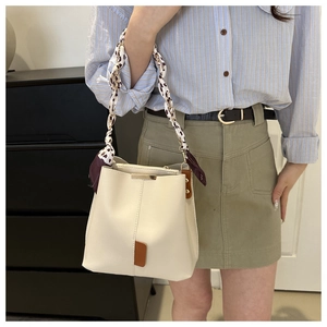 Detail of cream bucket bag with leopard print silk scarf chain strap and gold hardware