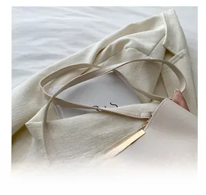 Detailed shot of cream leather bucket bag with elegant silk scarf and gold hardware
