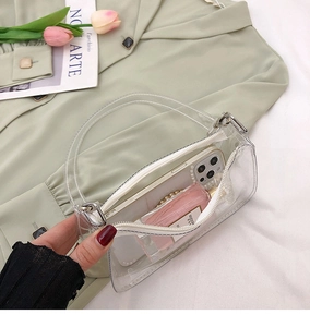 Close-up of a clear PVC mini tote bag showing its zipper and interior storage capacity