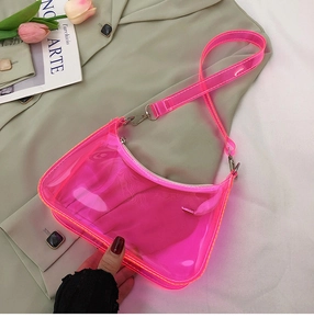 Detail showing neon pink transparent PVC shoulder bag with metal zipper and strap