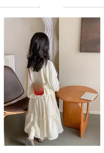 Vue arrière d'un mannequin enfant portant un mini sac bandoulière rouge à nœud