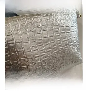 Close-up of silver metallic embossed leather texture and uniform croc pattern on handbag