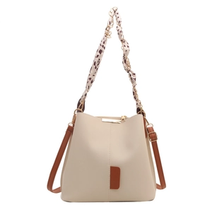 Chic beige bucket bag with brown leather trim and decorative leopard print silk scarf