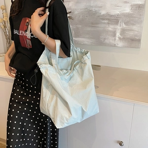 Minimalist light blue nylon bucket bag with drawstring detail for daily commuting
