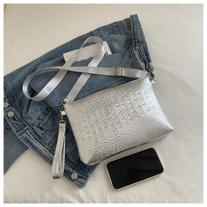 Close-up of silver embossed crocodile pattern handbag with detachable shoulder straps