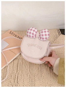 Détail du petit sac à bandoulière rose pour fille avec nœud à carreaux et broderie chat