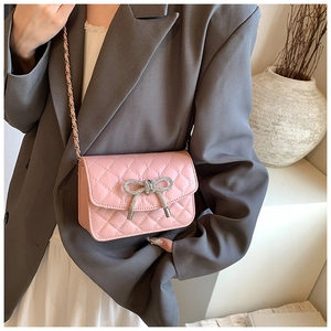 Roze gewatteerde mini crossbodytas met strasstrikje en kettingriem gedragen door model