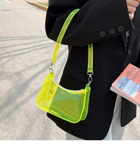 Detail view of neon yellow-green translucent PVC crescent baguette bag on shoulder