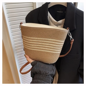 Macro shot of striped woven bucket bag texture with brown leather strap detail