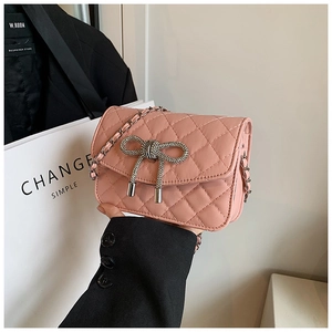 Detail van roze gewatteerde crossbodytas met strass-strik en metalen ketting schouderband