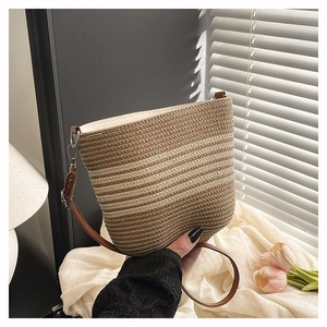 Detail of hand-held woven crossbody bag with striped pattern and leather strap