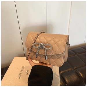 Detail van de beige ruitvormige textuur met een fonkelende strass-strikgesp