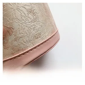 Gros plan du sac seau en jacquard avec broderie florale et surpiqûres en cuir rose