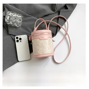 Détail d'un mini sac seau rose montrant le tissu jacquard et la poignée supérieure