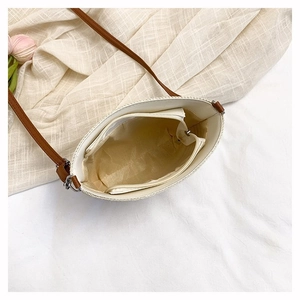 Detail view of the interior compartment and lining of this woven bucket shoulder bag