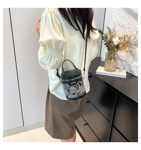 Détail du sac seau noir avec broderie blanche et bandoulière réglable pratique