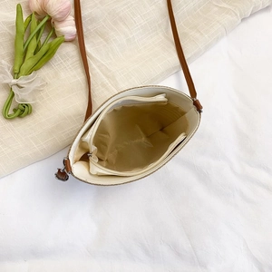 Internal view of a woven bucket bag with silk lining and zipper pocket detail