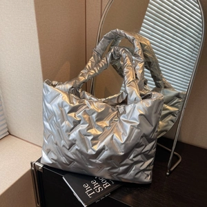 Metallic silver quilted tote bag with padded handles and spacious interior design