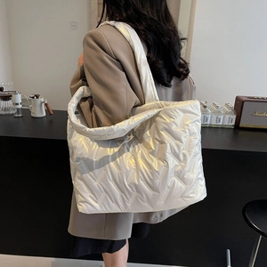 Close-up of white quilted tote bag featuring a padded down-like material for winter commute